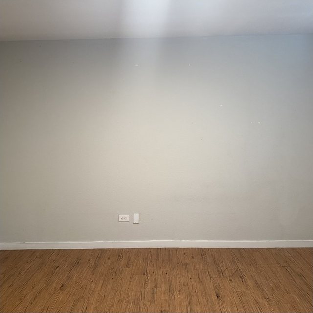 Apartment living-room wall with patches and marks before painting.